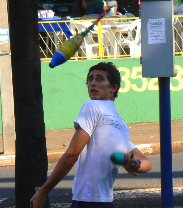 a boy hitting a ball with a baseball bat