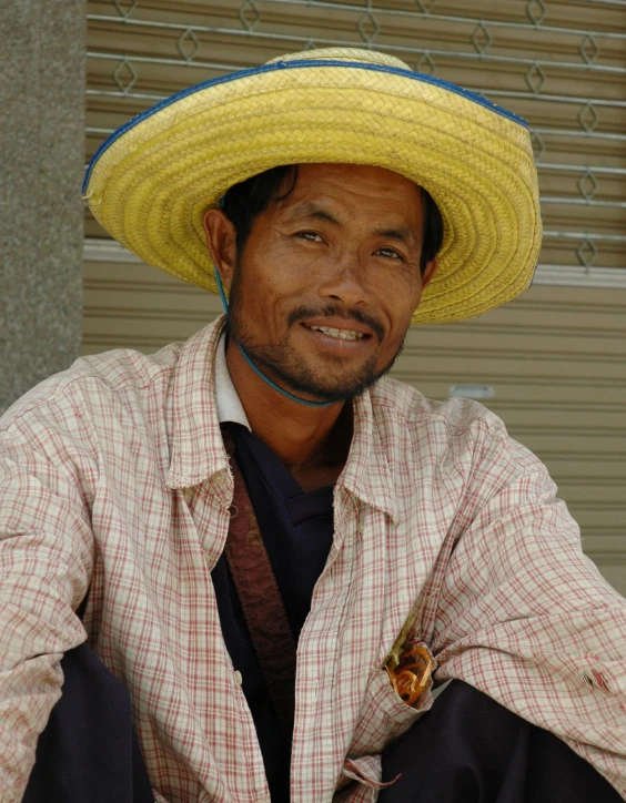 a man wearing a large hat and plaid shirt