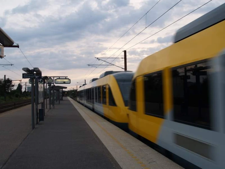 a long train traveling down tracks near a station