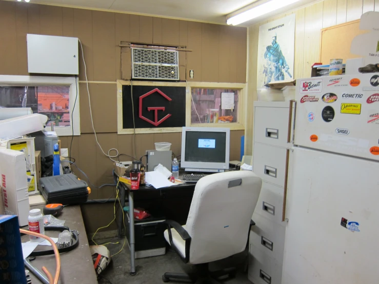 an office with a cluttered desk area and lots of magnets