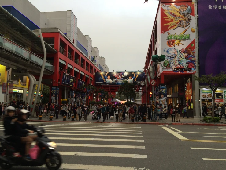 people on motor scooters near buildings on street