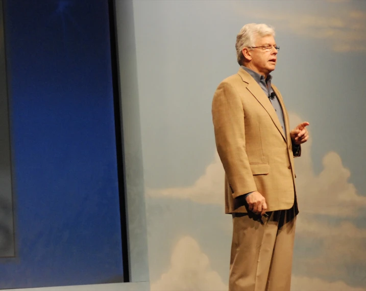 an older man standing in front of a podium and talking