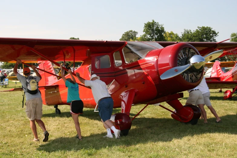 two people standing on the nose of a small plane