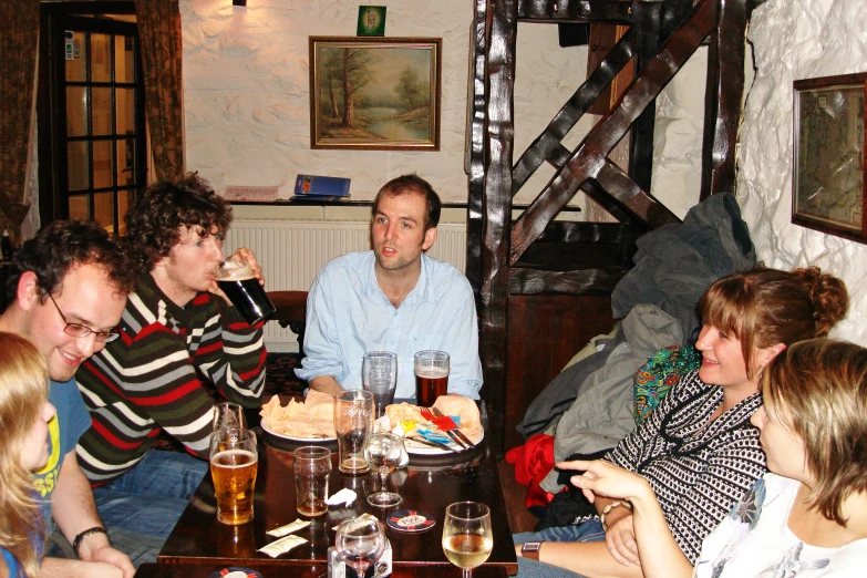 a group of people sitting around a wooden table