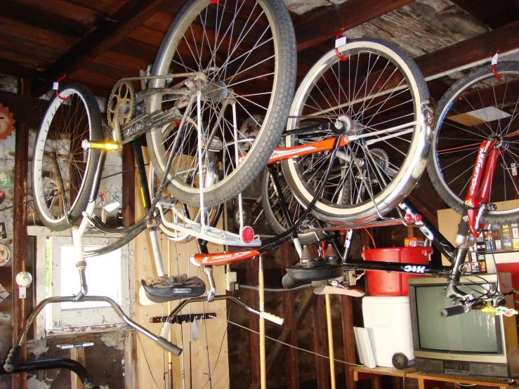 two bicycles hanging on a wall in front of a television