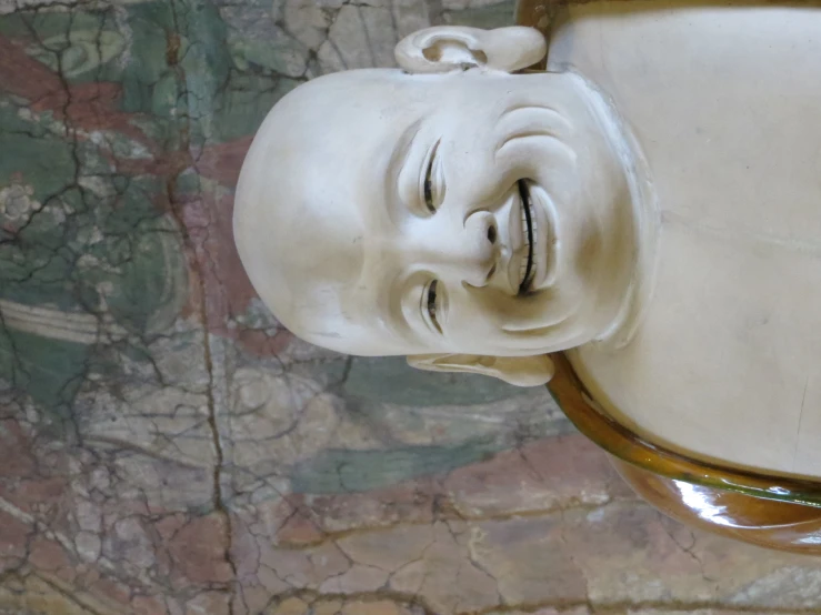 a smiling buddha statue with arms wrapped around it
