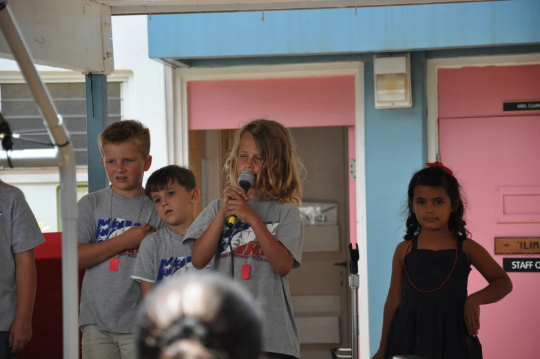 a group of children singing and taking pictures with a camera