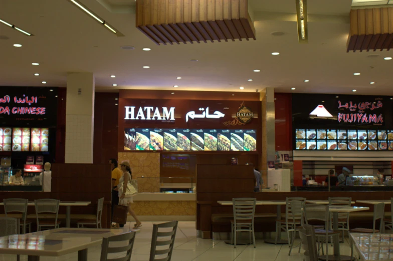 two people walking past a restaurant at night