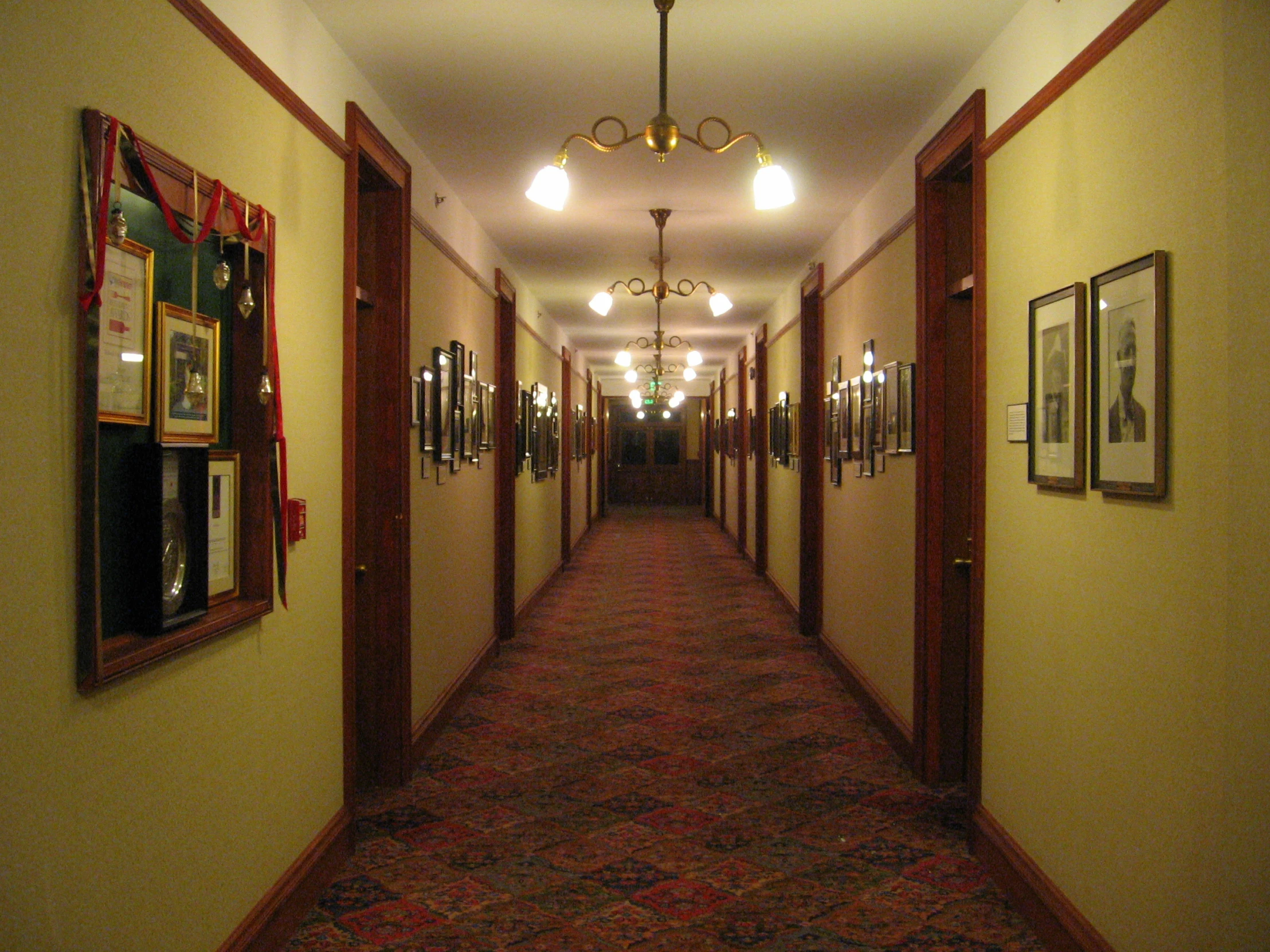 there are several pictures on the wall in this hallway