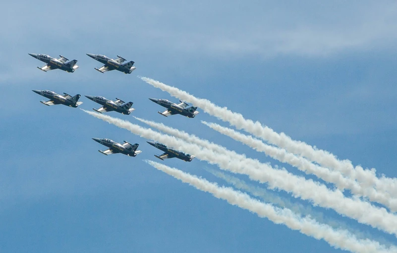 seven jet planes flying in formation in the sky