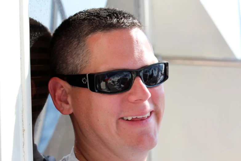 man in black shades standing near a window