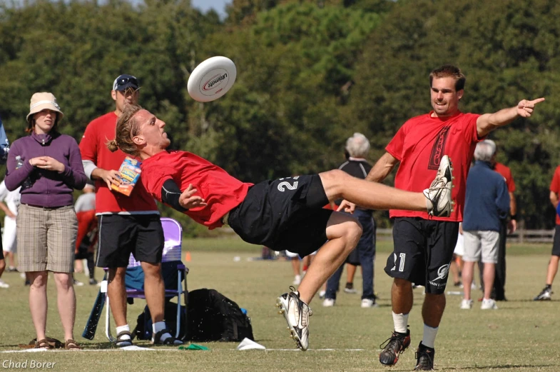 some people playing frisbee on a grass field