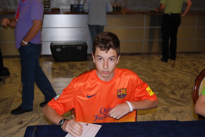 the young man is sitting at a table