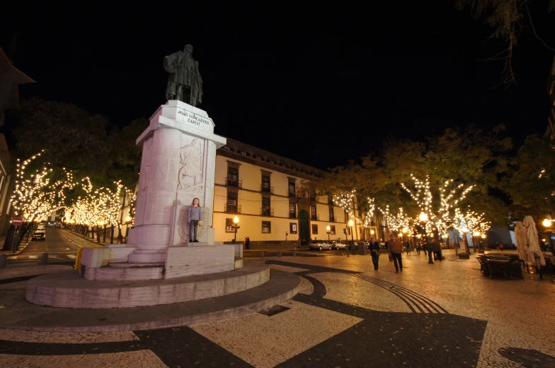 statue with people in town square on a christmas evening