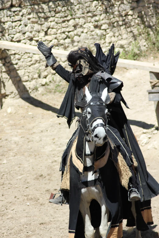 a male in a costume riding on top of a horse