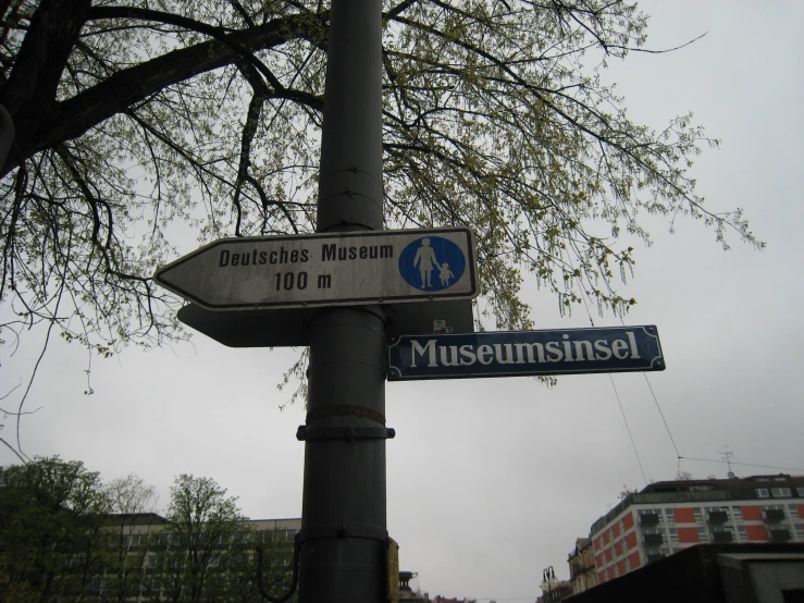 two street signs hanging from the side of a metal pole