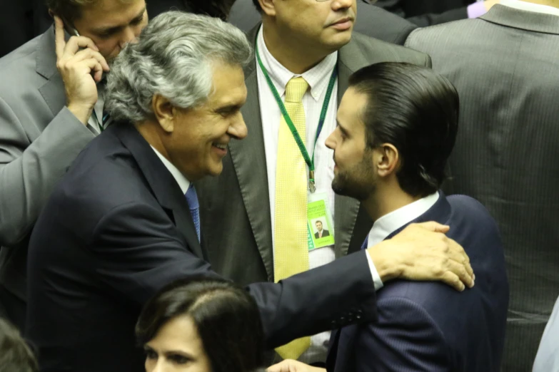 two men hug each other while one man looks at them