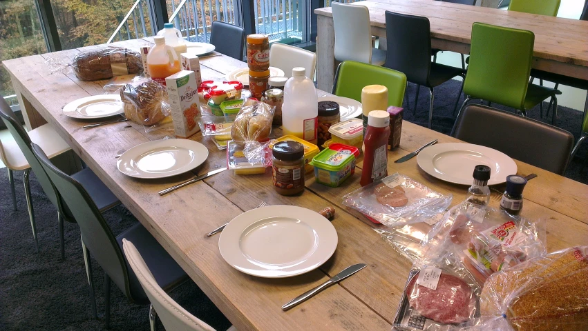 a table is set for two with food in plastic bags