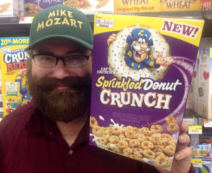 a man with a beard holds up a cereal box