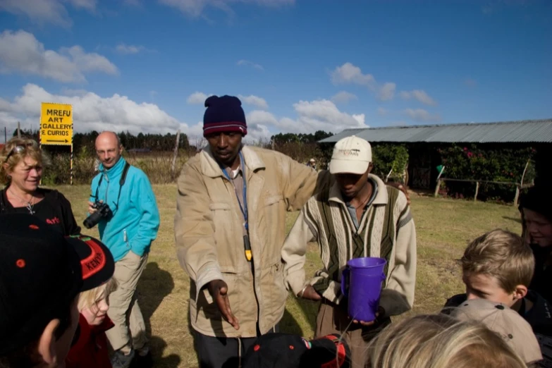 a man standing with other people holding buckets