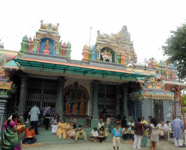many people standing around a temple on the street
