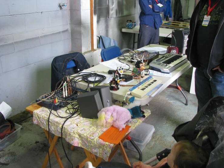 a table topped with many electronic equipment in front of a wall