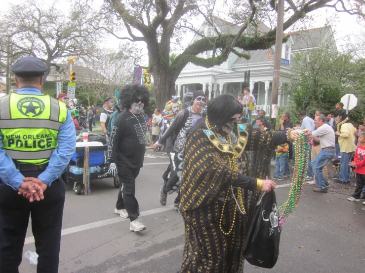 some people in costume on the street and one is holding a police cord