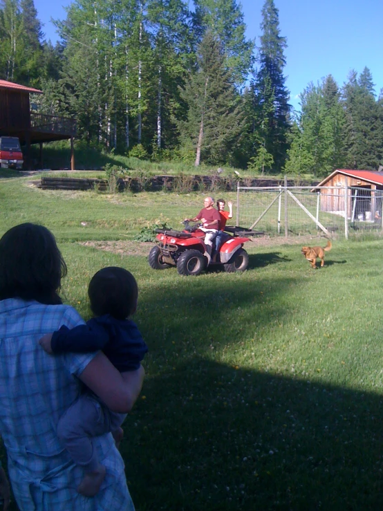 a man riding a red lawn mower in a yard