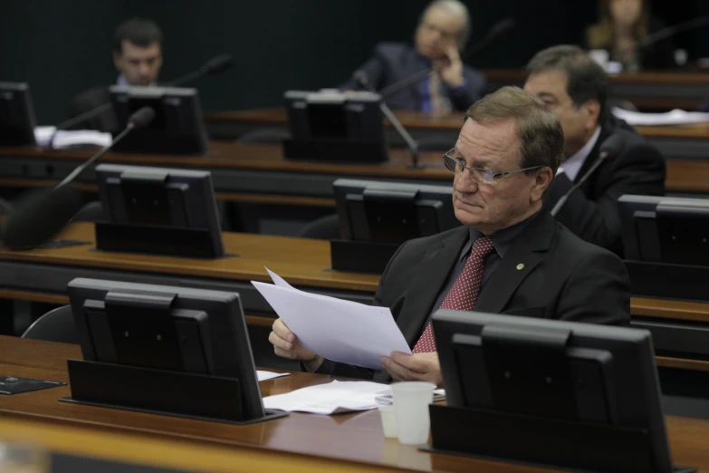 a person with glasses on is reading the paper