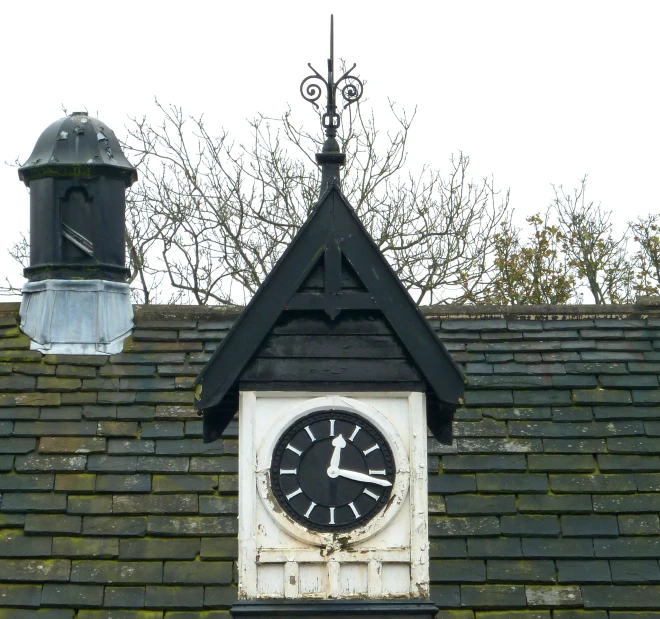 a clock attached to a roof that shows 11 o'clock