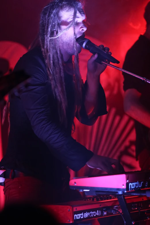 a young man singing in front of a dj equipment set