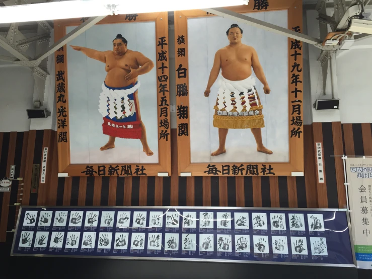 two large chinese posters and two men in traditional clothing