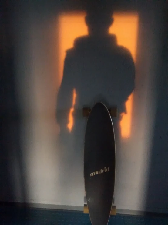 skateboard with light projected on wall behind it