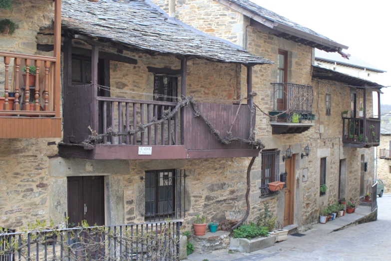 a wooden balcony with wrought iron railings in a residential area