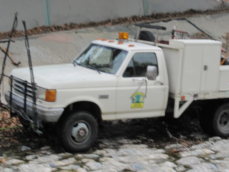 a white work truck parked next to a building