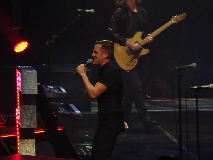 an image of man playing the guitar and singing on stage