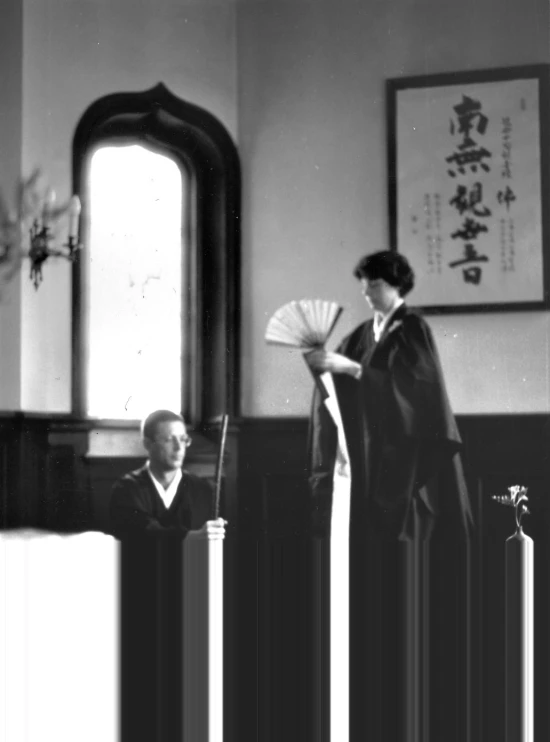 old asian woman with fan standing next to man in room