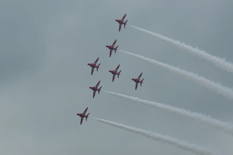 seven airplanes flying in formation in the sky