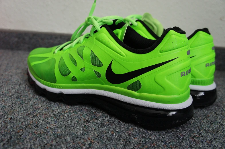 a pair of neon green nike sneakers laces together
