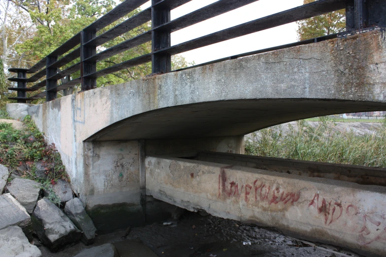 an overpass on a bridge with graffiti painted on the under side