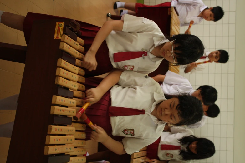 young children wearing uniforms playing an instrument in a school