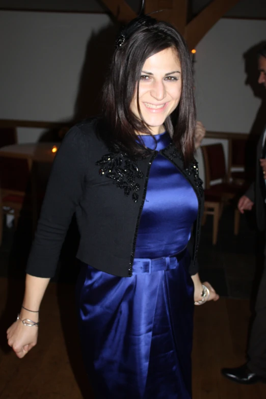 a woman wearing a blue dress and a black jacket