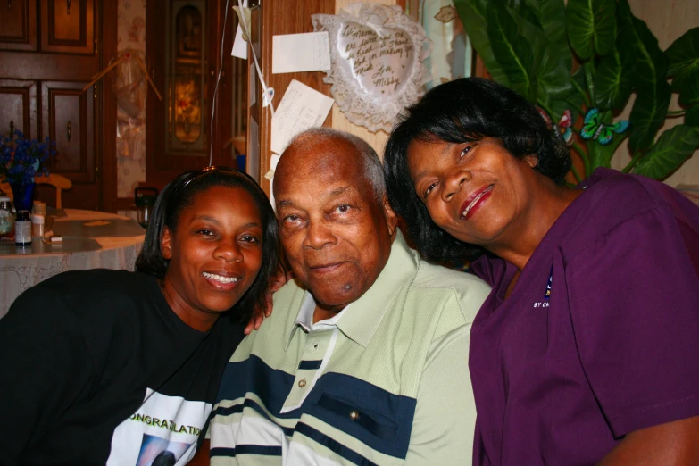 two women and a man with two s smiling at the camera