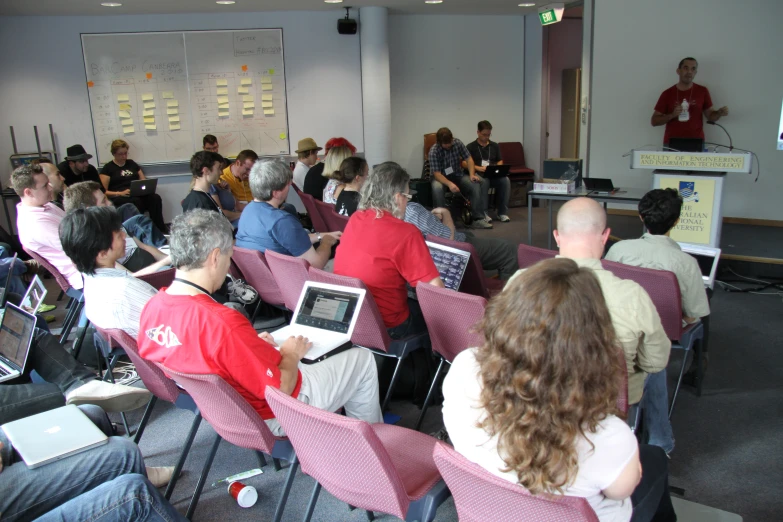 group of people sitting in front of a screen