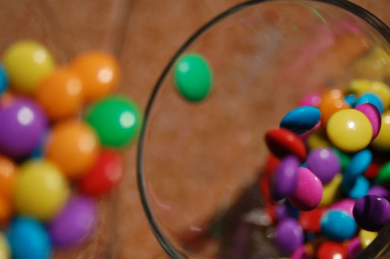 the colored candy is in a bowl on the table