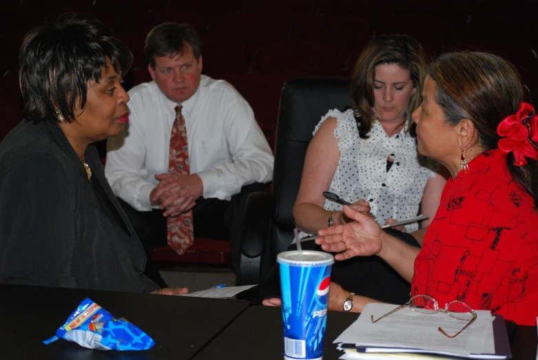 three women and one man sitting at a table in a room