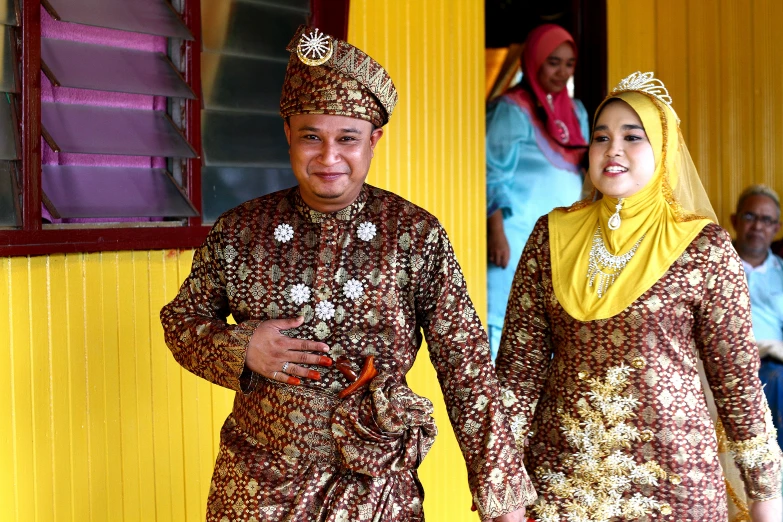 a couple wearing matching gold and brown clothing