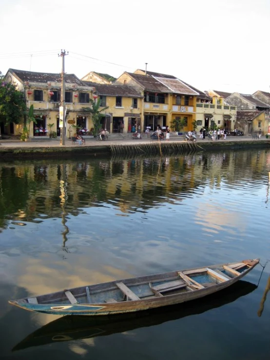 a small boat floating on top of water next to buildings