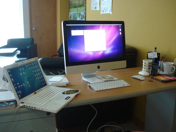 an empty computer desk topped with two laptops