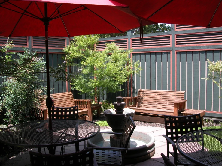 outside sitting area with table, chairs, and umbrellas